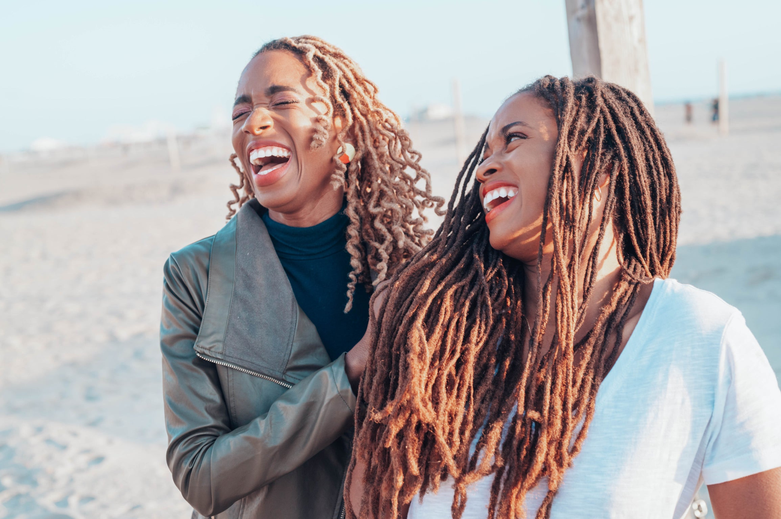Two women laughing together by the sea