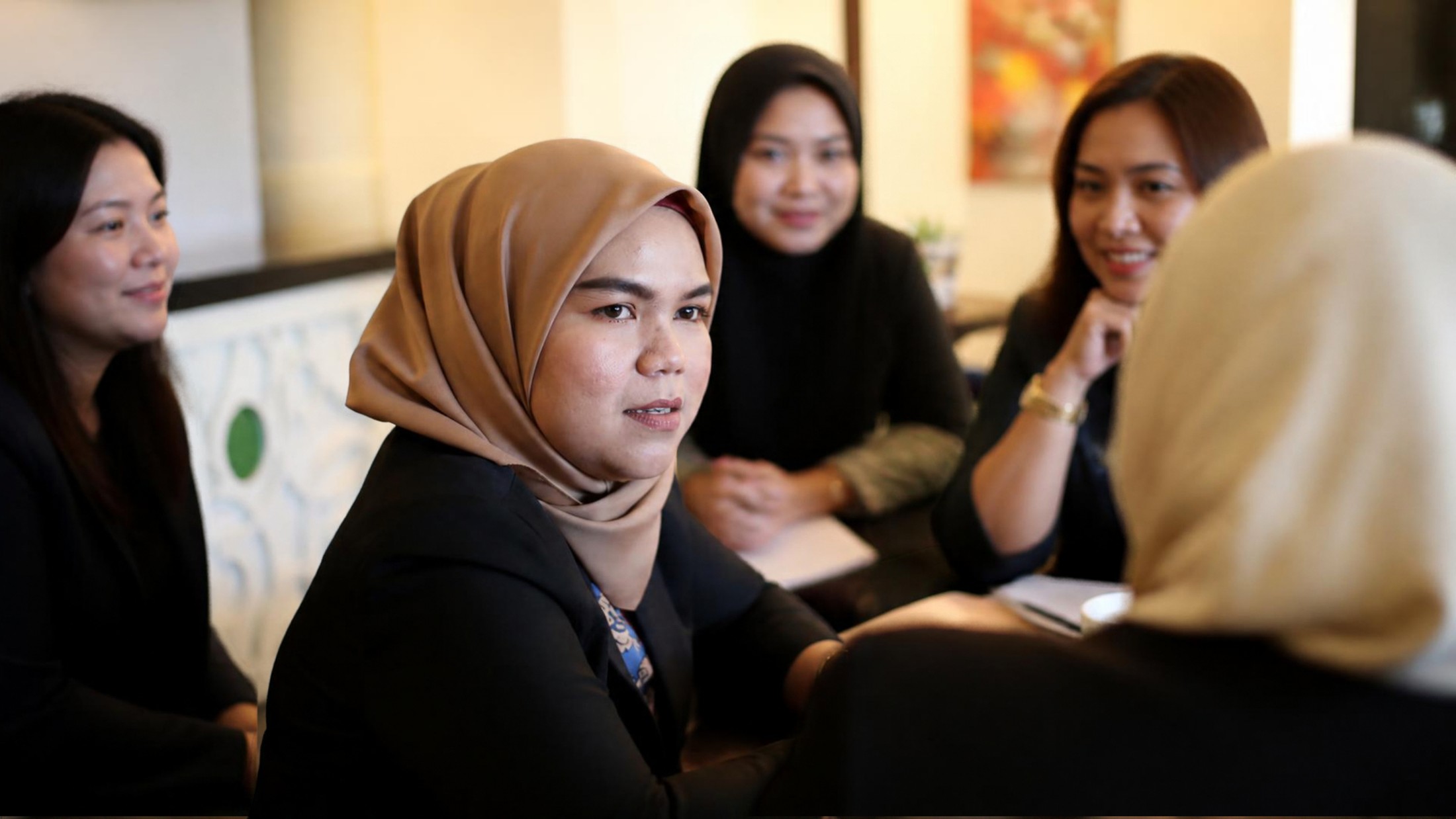 Women in conversation, including women wearing hijab